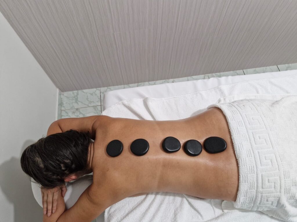 Aplicação de massagem relaxante com pedras quentes.